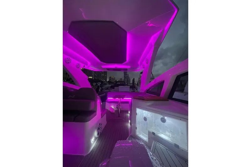 Slide: The Image of 2023 NX Boats NX340 interior with vibrant purple LED lighting at night. - 11