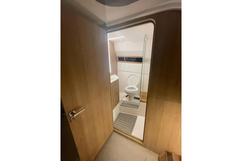 Slide: The Image of 2023 NX Boats NX340 bathroom interior with wooden door and modern fixtures. - 13