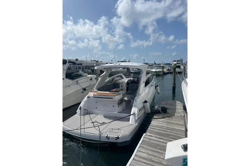 Slide: The Image of 2023 NX Boats NX340 docked at marina under clear blue sky. - 4