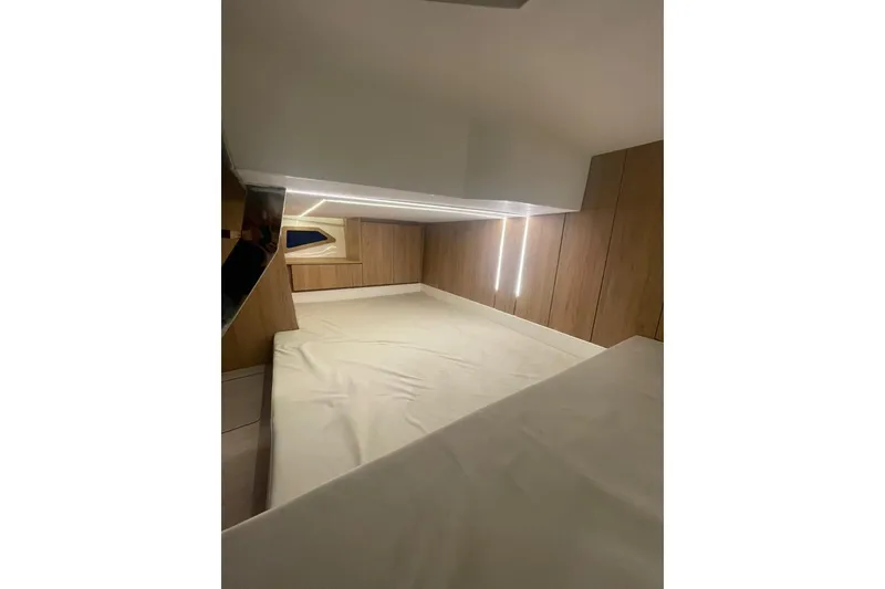 Slide: The Image of 2023 NX Boats NX340 cabin interior with modern wood paneling and ambient lighting. - 7