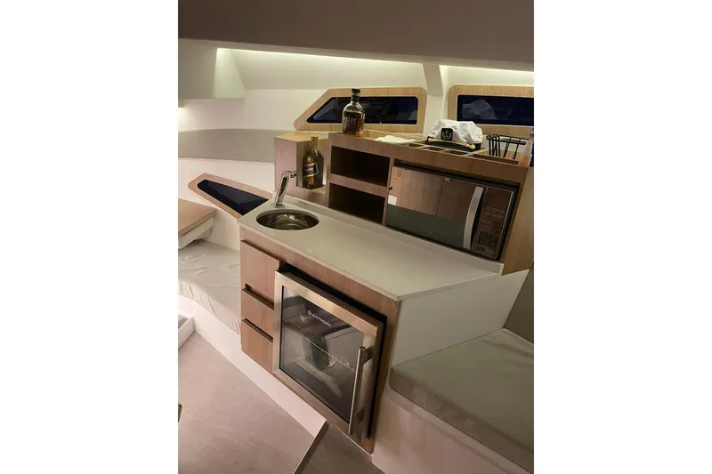 Slide: The Image of Interior of 2023 NX Boats NX340, featuring a modern kitchenette with sink and microwave. - 8