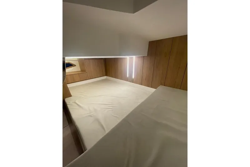 Slide: The Image of 2023 NX Boats NX340 cabin interior with wooden paneling and cozy sleeping area. - 9