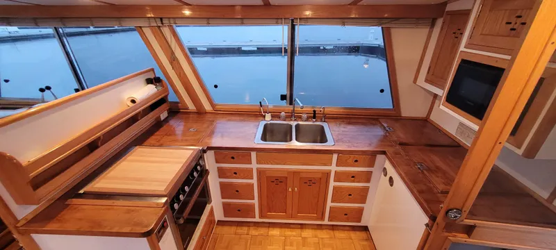 Slide: The Image of 1989 Duffy Wilbur 42 Flybridge Cruiser kitchen with wooden cabinetry and dual sinks. - 23