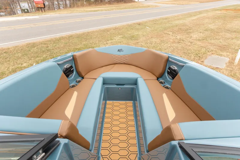 Slide: The Image of 2026 MasterCraft NXT23 boat interior with blue and tan seating, hexagonal floor design. - 10