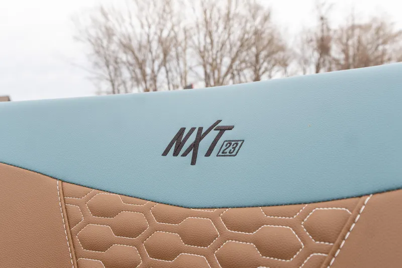 Slide: The Image of 2026 MasterCraft NXT23 boat seat with hexagonal stitching and logo detail. - 12