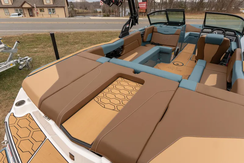 Slide: The Image of 2026 MasterCraft NXT23 boat interior with tan and blue seating, hexagonal pattern design. - 14