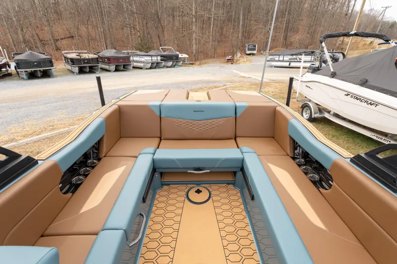 Slide: The Image of 2026 MasterCraft NXT23 boat interior with tan and blue seating, hexagonal floor design. - 5