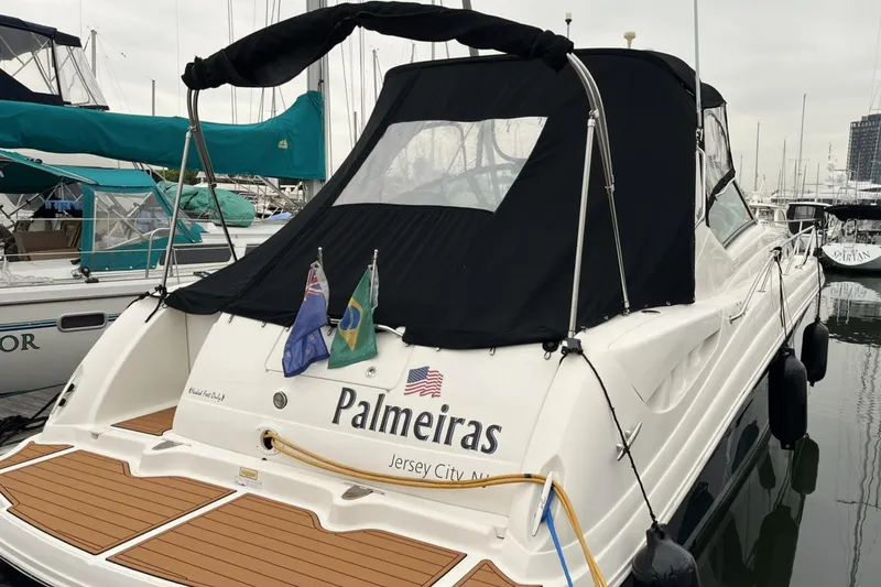 Slide: The Image of 2006 Sea Ray 340 Sundancer boat docked, featuring "Palmeiras" name and flags, Jersey City. - 2
