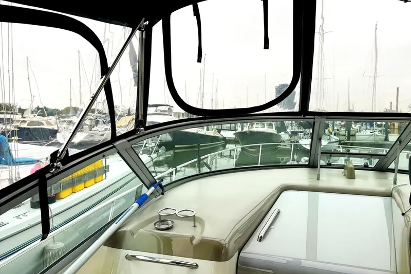 Slide: The Image of Interior view of 2006 Sea Ray 340 Sundancer yacht at marina, showcasing helm and docked boats. - 5