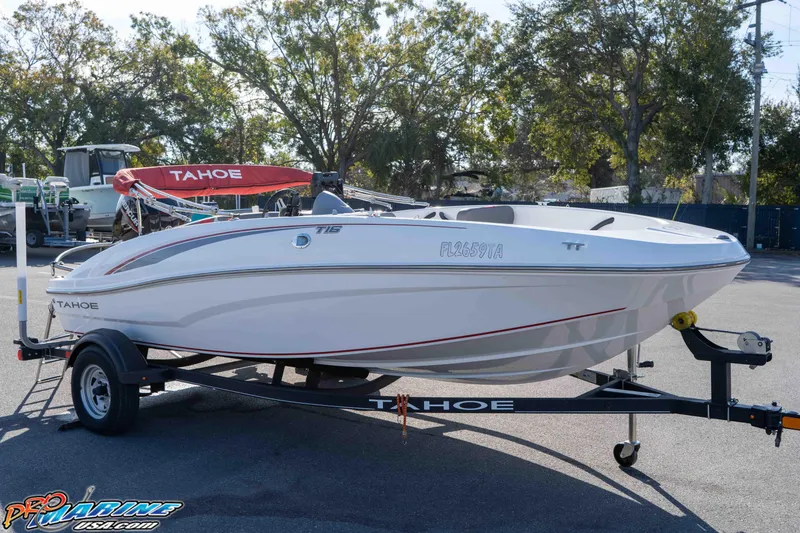The Image of 2021 Tahoe T16 boat on trailer, parked outdoors with trees in background. - 1