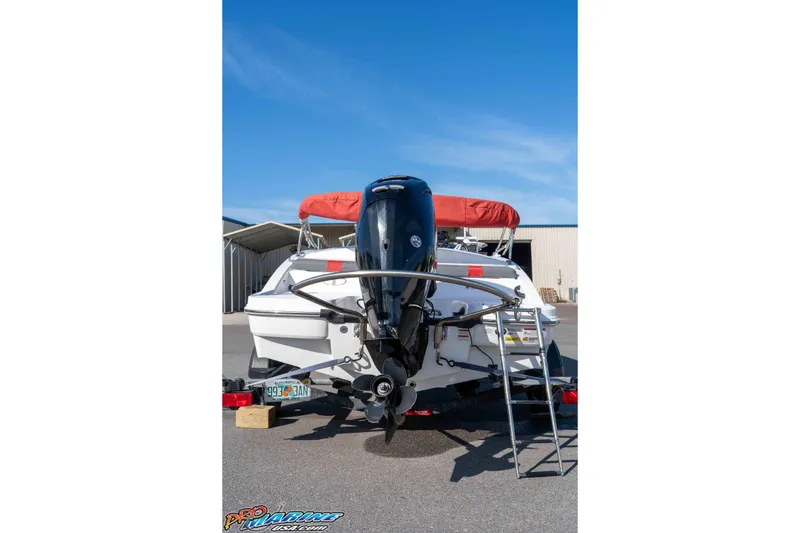 Slide: The Image of 2021 Tahoe T16 boat with outboard motor and ladder, parked outdoors. - 12