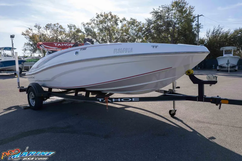 Slide: The Image of 2021 Tahoe T16 boat on trailer in outdoor setting, showcasing sleek design and branding. - 20