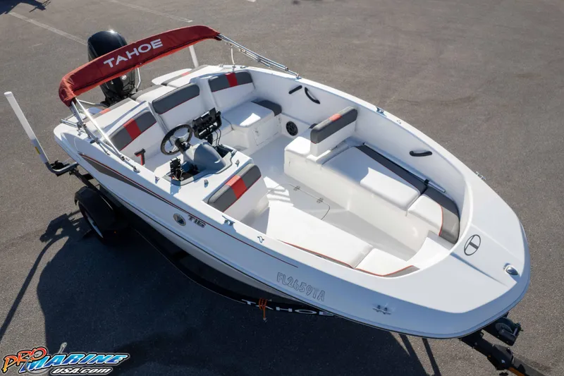 Slide: The Image of 2021 Tahoe T16 boat with red canopy and seating, parked on a trailer. - 22