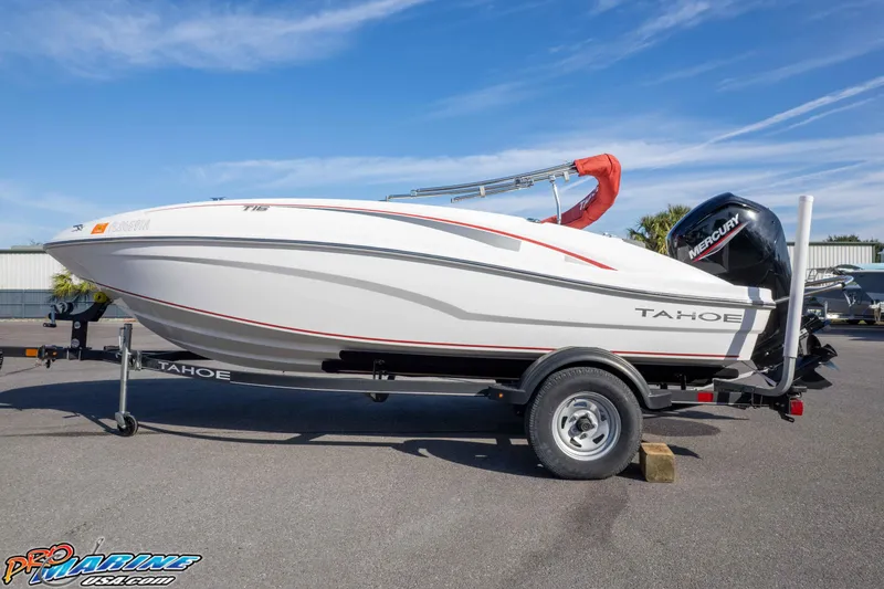 Slide: The Image of 2021 Tahoe T16 boat on trailer with Mercury engine, parked outdoors under blue sky. - 29
