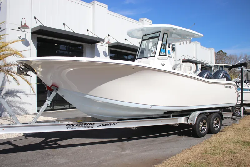 The Image of 2026 Tidewater 256 LXF boat on trailer, parked outside a modern building. - 0