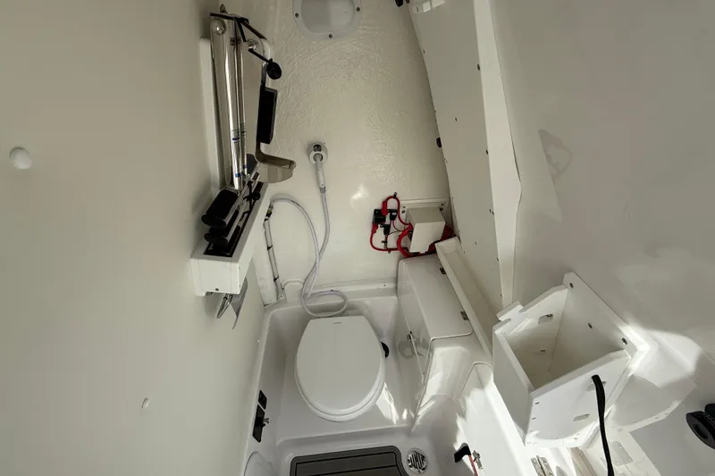 Slide: The Image of 2026 Tidewater 256 LXF boat interior with compact marine toilet and storage features. - 10