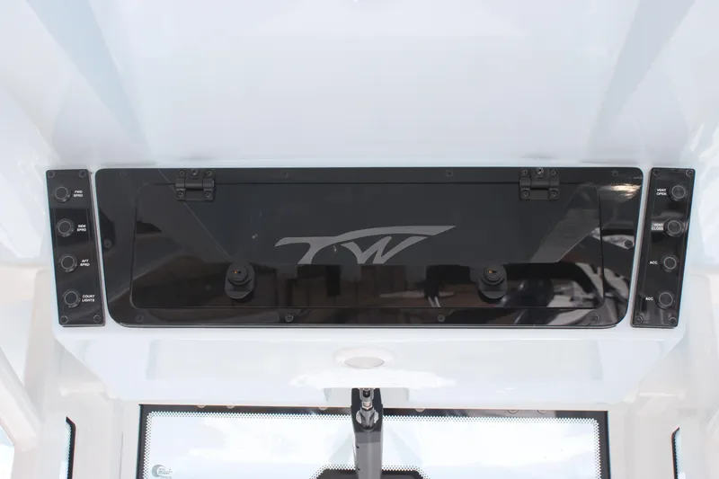 Slide: The Image of 2026 Tidewater 256 LXF boat dashboard with control panel and storage compartment. - 19