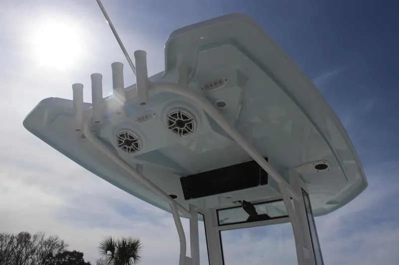 Slide: The Image of 2026 Tidewater 256 LXF boat top with rod holders and speakers under sunny sky. - 20