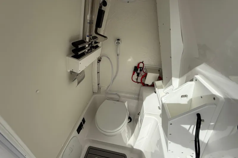 Slide: The Image of 2026 Tidewater 256 LXF boat interior with compact marine toilet and storage. - 9