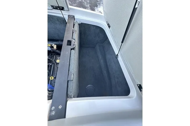 Slide: The Image of Open storage compartment in 2004 MasterCraft XStar 23 boat, showing interior space. - 16