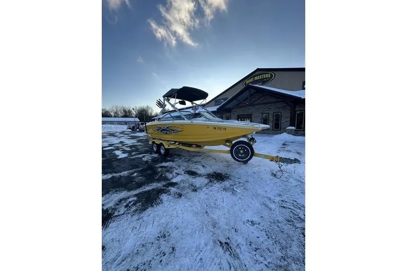 Slide: The Image of Yellow 2004 MasterCraft XStar 23 boat on trailer in snowy outdoor setting. - 19