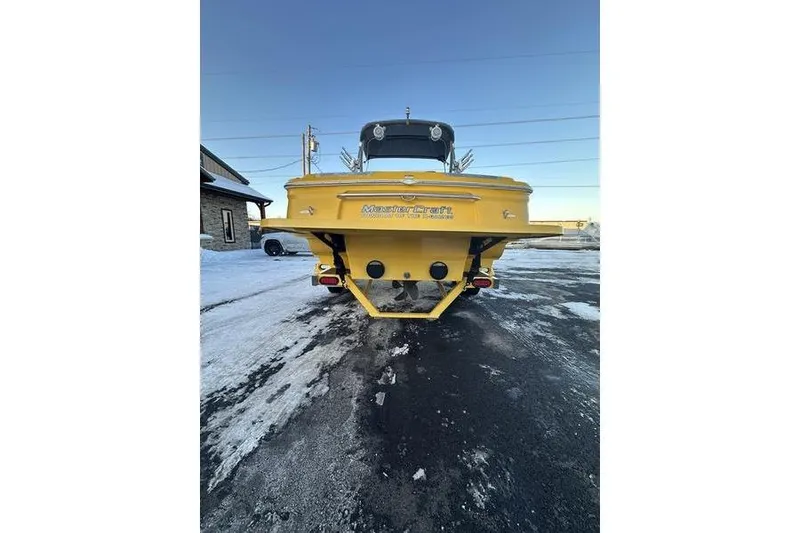 Slide: The Image of Yellow 2004 MasterCraft XStar 23 boat on snowy pavement, rear view. - 21