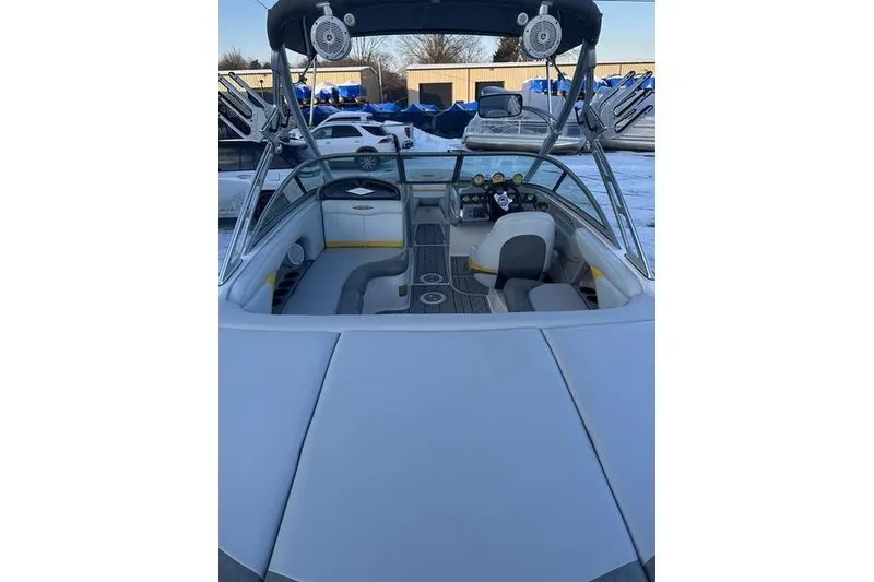 Slide: The Image of 2004 MasterCraft XStar 23 boat interior with seating and dashboard, parked outdoors. - 7
