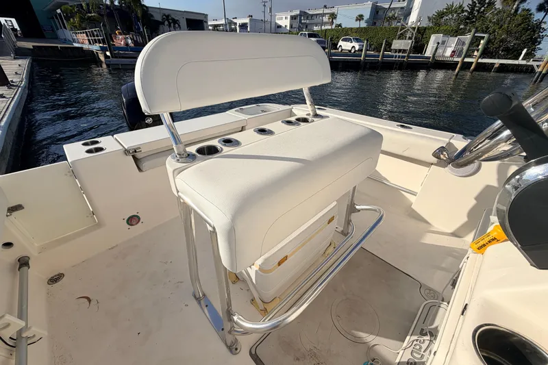 Slide: The Image of 2020 Cobia 220 Center Console boat interior with white seating and cup holders. - 14