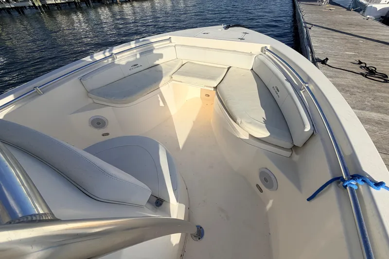 Slide: The Image of 2020 Cobia 220 Center Console boat interior with cushioned seating and dock view. - 29