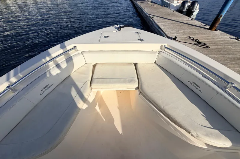 Slide: The Image of 2020 Cobia 220 Center Console boat interior with cushioned seating at dock. - 32