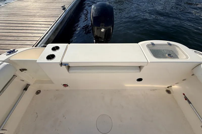 Slide: The Image of 2020 Cobia 220 Center Console boat interior with motor and dock view. - 8