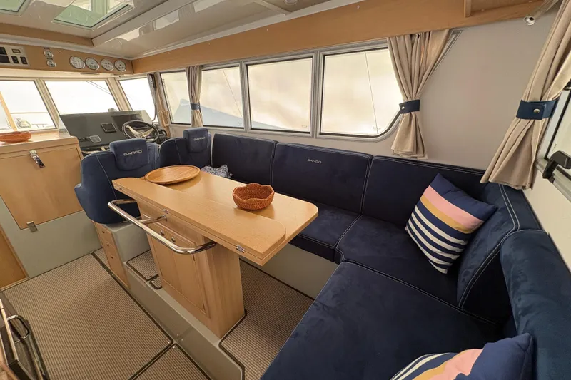 Slide: The Image of Interior of 2021 Sargo 36 boat with blue seating and wooden table. - 11