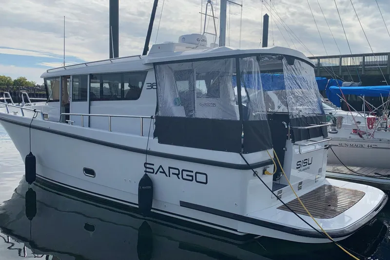 Slide: The Image of 2021 Sargo 36 boat docked, featuring sleek design and covered rear deck. - 2