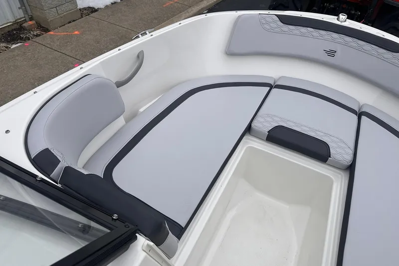 Slide: The Image of 2026 Bayliner M17 boat interior with gray cushioned seating and storage compartment. - 10