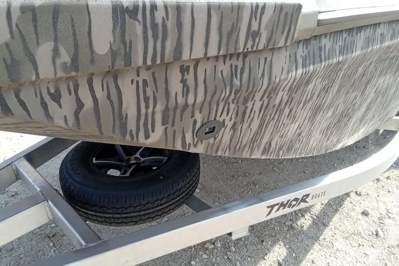 Slide: The Image of 2026 Thor 1900 Low Country Elite boat with camouflage design on a trailer. - 5