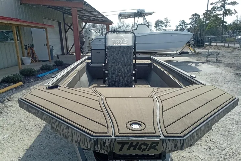 Slide: The Image of 2026 Thor 1900 Low Country Elite boat with custom deck design, parked outdoors. - 7