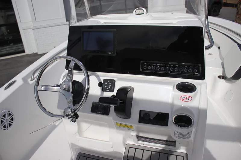 Slide: The Image of 2026 Tidewater 198 CC Adventure boat dashboard with steering wheel and control panel. - 18