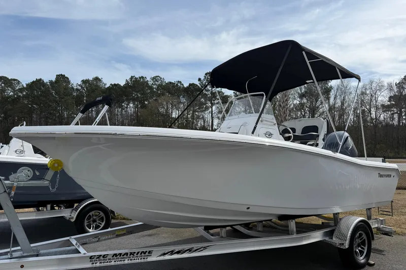 Slide: The Image of 2026 Tidewater 198 CC Adventure boat on trailer with canopy, parked outdoors. - 2