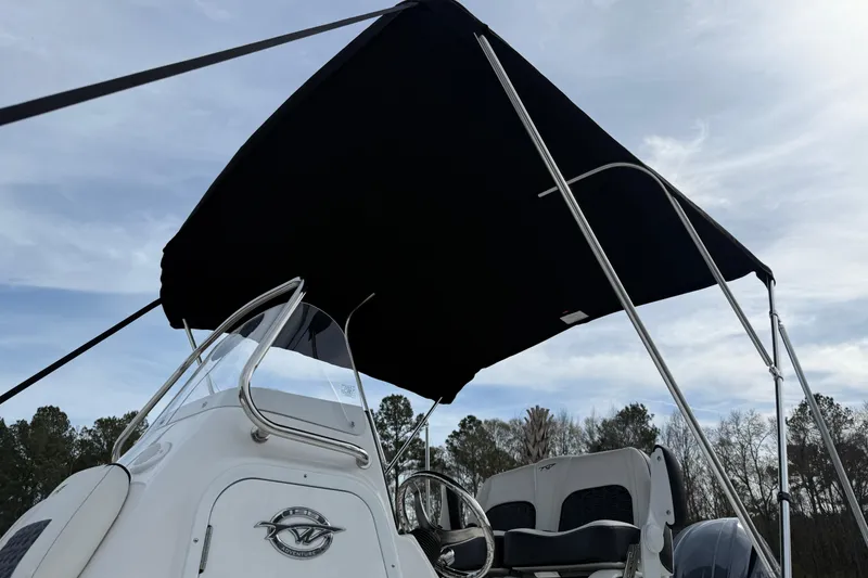 Slide: The Image of 2026 Tidewater 198 CC Adventure boat with canopy under a cloudy sky. - 28