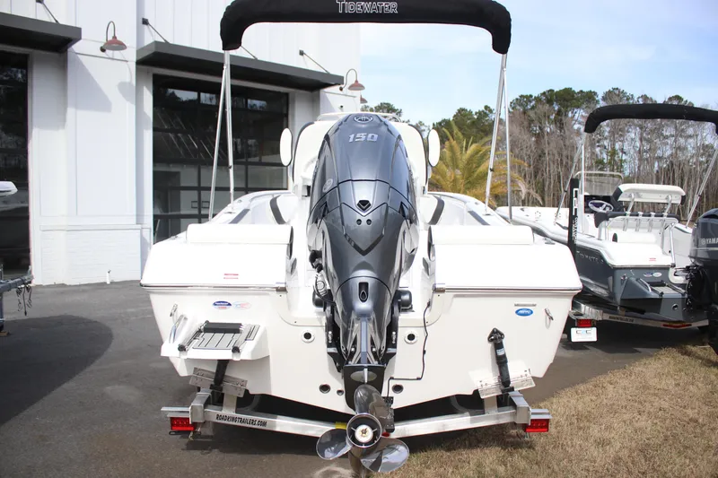 Slide: The Image of 2026 Tidewater 198 CC Adventure boat with powerful outboard motor, parked outdoors. - 6