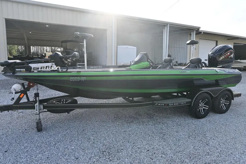 The Image of 2022 Skeeter ZXR20 fishing boat on trailer, green and black design, parked outdoors. - 1