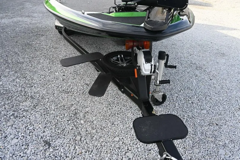 Slide: The Image of 2022 Skeeter ZXR20 boat trailer on gravel surface, featuring a spare tire and winch. - 4