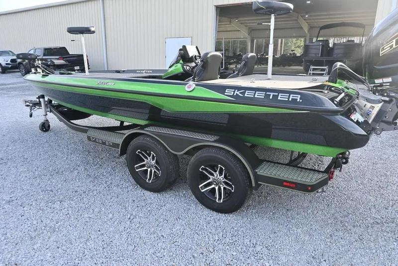 Slide: The Image of 2022 Skeeter ZXR20 boat in green and black on a trailer, parked outside a building. - 7