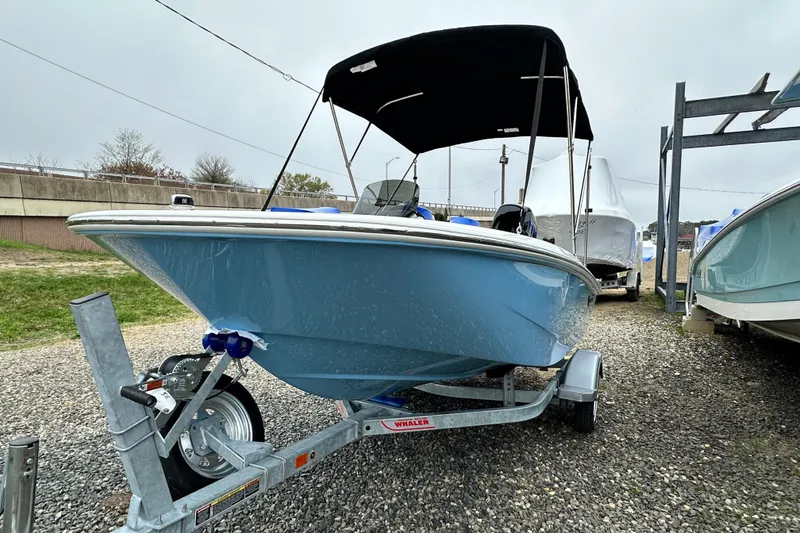 Slide: The Image of 2026 Boston Whaler 130 Super Sport on trailer, blue hull, black canopy. - 24