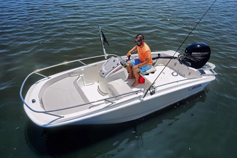 Slide: The Image of Manufacturer Provided Image: 2025 Boston Whaler 130 Super Sport boat on water with person steering. - 4