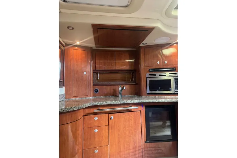 Slide: The Image of Luxurious 2005 Sea Ray 420 Sundancer yacht kitchen with wood cabinetry and modern appliances. - 11