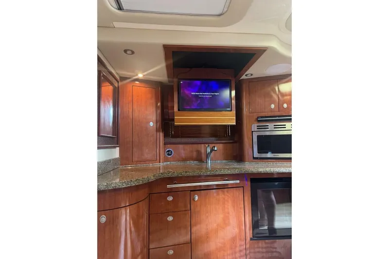 Slide: The Image of Luxurious 2005 Sea Ray 420 Sundancer yacht interior with wood cabinetry and modern appliances. - 12