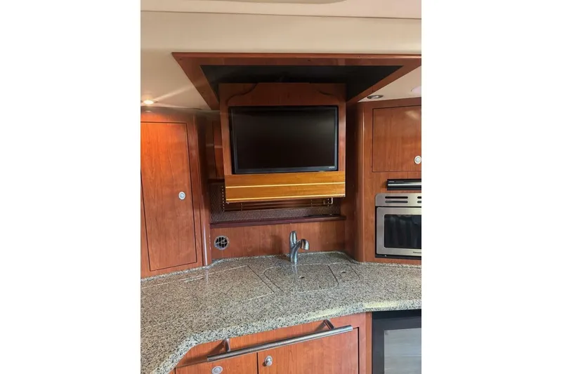 Slide: The Image of Luxurious 2005 Sea Ray 420 Sundancer yacht interior with TV and modern kitchen amenities. - 13