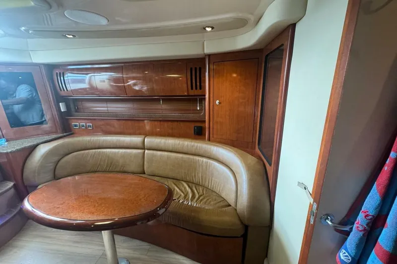 Slide: The Image of 2005 Sea Ray 420 Sundancer interior with curved leather seating and wooden cabinetry. - 15