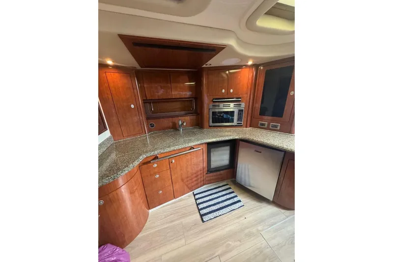 Slide: The Image of Luxurious 2005 Sea Ray 420 Sundancer yacht kitchen with wood cabinetry and modern appliances. - 19